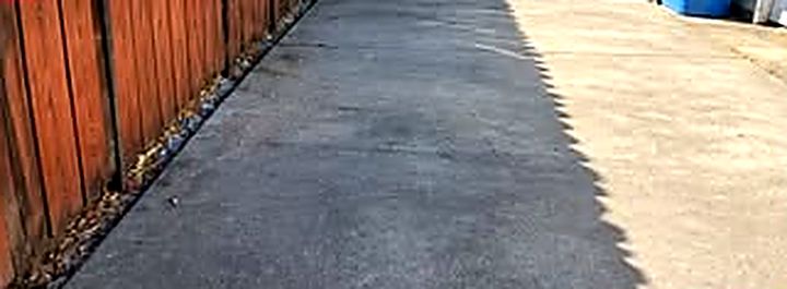 After: the same concrete patio cleared along the fence